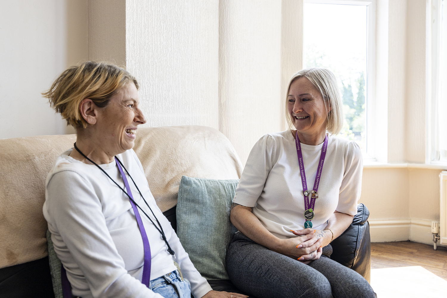 Supported living staff member speaking with tenant in housing association property photographed for care sector marketing