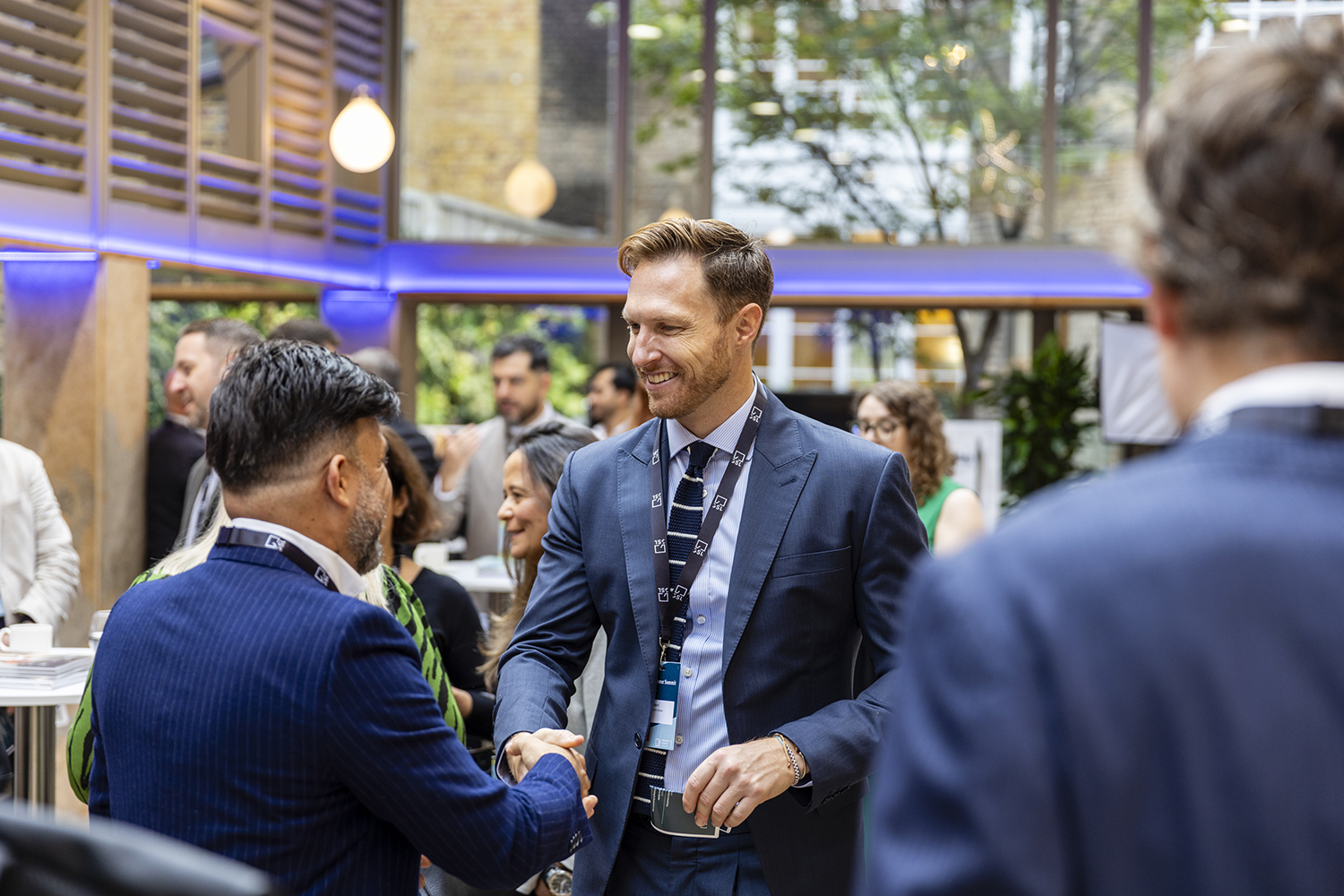 Business professionals networking and shaking hands at London conference event