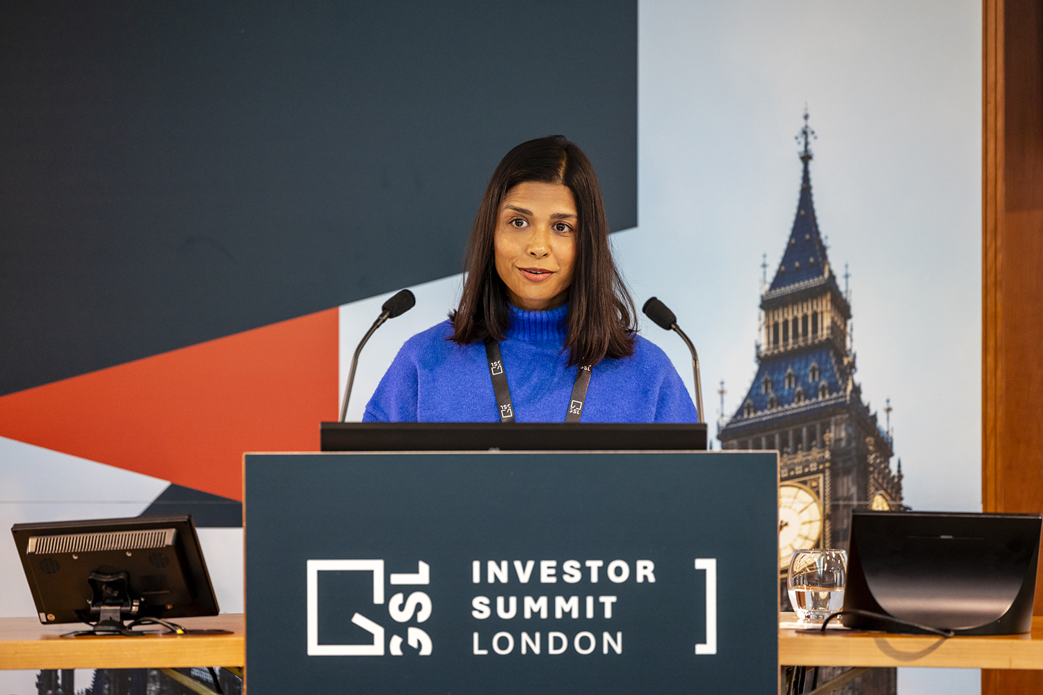 Speaker presenting at lectern during London business conference session