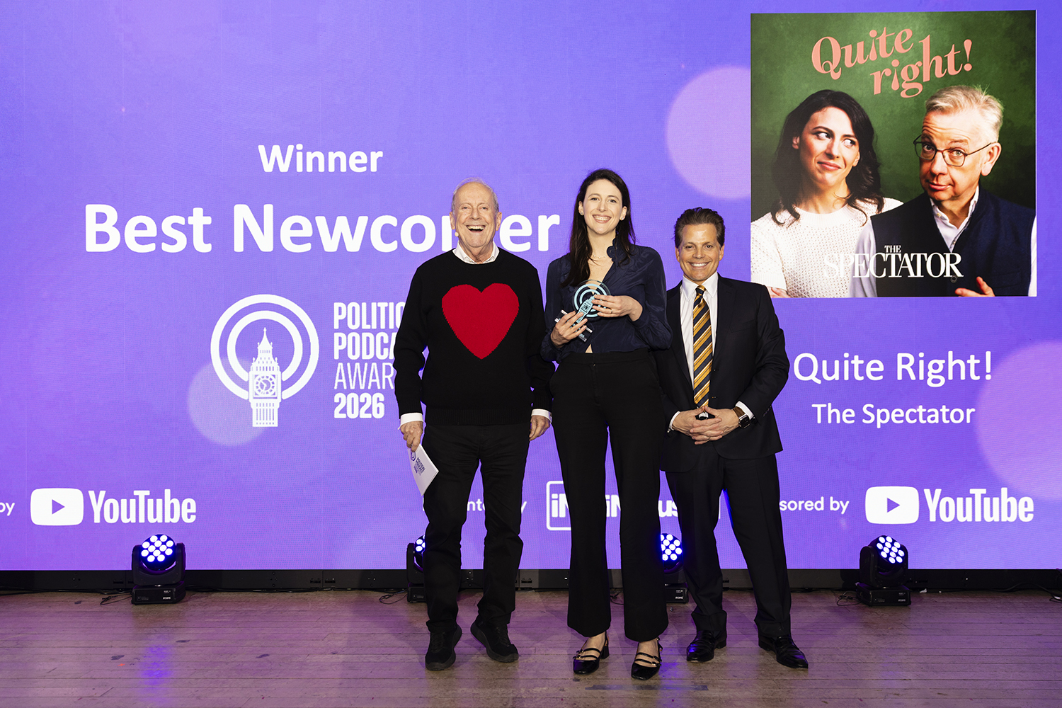 Award winners posing on stage with trophy at London awards ceremony